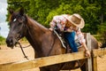 Cowgirl getting horse ready for ride on countryside Royalty Free Stock Photo