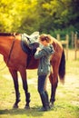 Cowgirl getting horse ready for ride on countryside Royalty Free Stock Photo