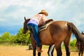 Cowgirl getting horse ready for ride on countryside Royalty Free Stock Photo