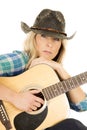 Cowgirl with guitar in blue shirt close look serious