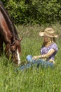 Cowgirl with her horse in the grass.