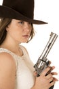 Cowgirl holding a big revolver with a dazed expression