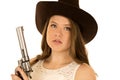 Cowgirl holding a big revolver with a serious expression