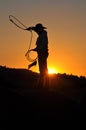 Silhouette Cowgirl Swings her Rope