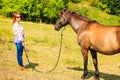 Cowgirl standing next to brown horse friend Royalty Free Stock Photo