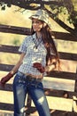 Cowgirl in stetson next to wooden fence Royalty Free Stock Photo