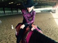 Girl in cowboy hat on horse in paddock