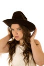 Cowgirl wearing a white dress adjusting her cowboy hat Royalty Free Stock Photo