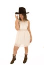 Cowgirl wearing a white dress tipping her cowboy hat Royalty Free Stock Photo