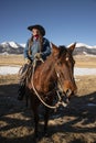 Cowgirl wrangler with cowboy hat portrait on saddled bay horse ready to work Royalty Free Stock Photo