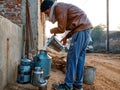 an cowherd man putting milk into containers on road in India January 2020