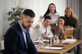 Coworkers bullying colleague in office, space for text Royalty Free Stock Photo