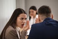 Coworkers bullying their colleague at workplace in office