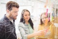 Coworkers looking at sticky notes pointed by female photo editor Royalty Free Stock Photo