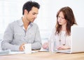 Coworkers making decisions. a two young design professionals sitting together and going over some paperwork.