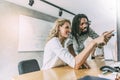 Coworkers in office pointing at desktop