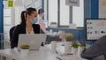 Coworkers with protection face masks working together in new normal office Royalty Free Stock Photo