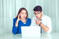 Coworkers shocked looking at laptop sitting at office table Royalty Free Stock Photo