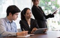 Coworkers team at work. Group of young business people in trendy working together in creative office with digital teblet Royalty Free Stock Photo