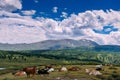 Cows on grass on a background of mountains and beautiful sky. Cows grazing on mountain meadow high. Summer landscape with cows Royalty Free Stock Photo