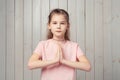 Coy little girl asking for favour, begging, say please with hands in pray beg gesture, frowning and looking sad Royalty Free Stock Photo