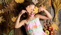 Coziest things about fall. Kid cute girl relax wooden background autumn attributes top view. Child long hair with dry