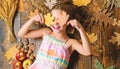 Coziest things about fall. Kid cute girl relax wooden background autumn attributes top view. Child long hair with dry