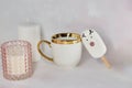 Cozy afternoon tea with white cup, cute marshmallow deer, gingerbread cookie and pink candle. Aesthetic tea time