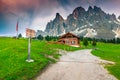 Cozy alpine chalet and wooden touristic signboard in Dolomites, Italy