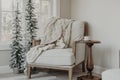 Cozy armchair covered with a blanket draped on it in the corner of a room near a window Royalty Free Stock Photo