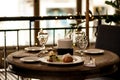 Cozy atmosphere at restaurant table with light snacks, cutlery and glasses