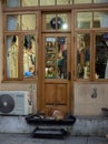 Cozy atmosphere in the window of a small shop. Warm light from the window. People at work in the workshop. The dog sleeps on the