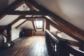 In a cozy attic room, exposed wooden beams arch overhead