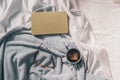 Cozy autumn background of a tea mug with a book and glasses on the bed. Selective focus. Warm tones Royalty Free Stock Photo