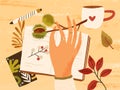 Cozy autumn composition with hand holding branch with chestnut, fall leaves, berries, notebook, pen and a cup of hot