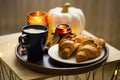 Cozy autumn morning breakfast with coffee cup, croissants and candles, cozy home Royalty Free Stock Photo