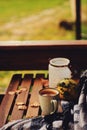 Cozy autumn morning at country house, cup of tea and warm blanket on wooden table Royalty Free Stock Photo