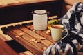 Cozy autumn morning at country house, cup of tea and warm blanket on wooden table Royalty Free Stock Photo