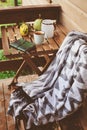 Cozy autumn morning at country house, cup of tea and warm blanket on wooden table Royalty Free Stock Photo