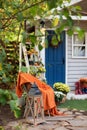 Cozy Autumn patio with chair, plaid, plants, wooden lantern, potted chrysanthemums. Halloween. Decorations in backyard for relax i Royalty Free Stock Photo