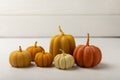 Cozy autumn pumpkin candles on white wood texture. Royalty Free Stock Photo