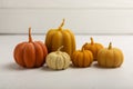 Cozy autumn pumpkin candles on white wood texture. Royalty Free Stock Photo