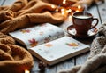 Cozy autumn scene with a notebook, cup of coffee, and warm blanket Royalty Free Stock Photo