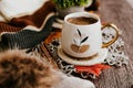 Cozy autumn still life with cup of hot black coffee. knitted hat and scarf on wooden background Royalty Free Stock Photo