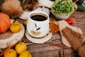 Cozy autumn still life with cup of hot black coffee. knitted hat and scarf on wooden background