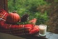 Cozy autumn still life: cup of hot coffee and opened book on vintage windowsill and rain outside. Autumn. Apartment. Rain