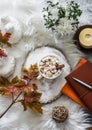 Cozy autumn still life - hot chocolate with marshmallows, garland, maple leaves, soft slippers on a fluffy carpet, top view