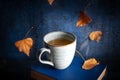 Cozy autumn still life with tea and books, with falling leaves and rain Royalty Free Stock Photo