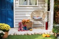 Cozy Autumn terrace with chair, plaid, rubber boots, baskets with chrysanthemums and pumpkins. Decorations in autumn patio for rel Royalty Free Stock Photo