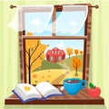 Cozy autumn window with beautiful fall view with trees, house and field. Book, apple and cup of tea on the windowsill Royalty Free Stock Photo